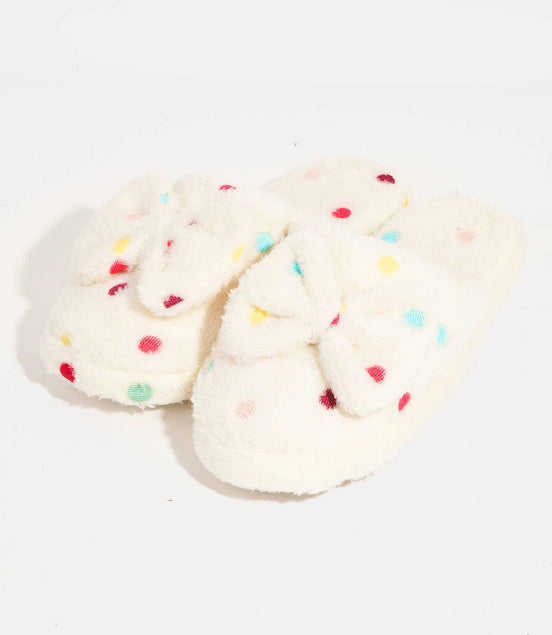 Pair of white slippers with colorful sprinkles on a light background