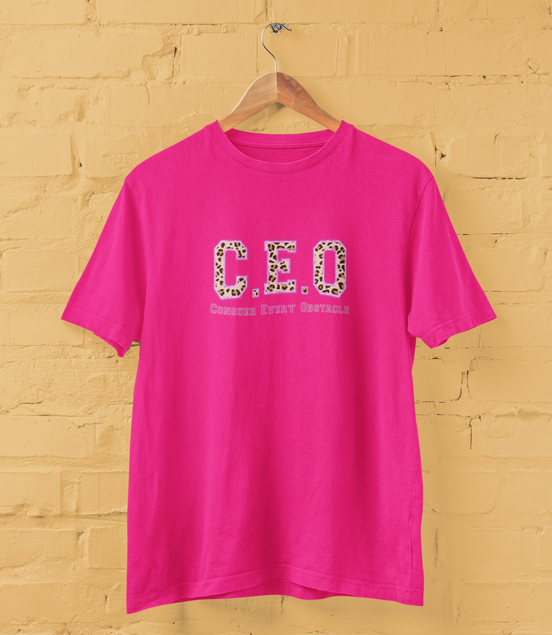 Pink t-shirt with 'CEO' print on a yellow brick wall background