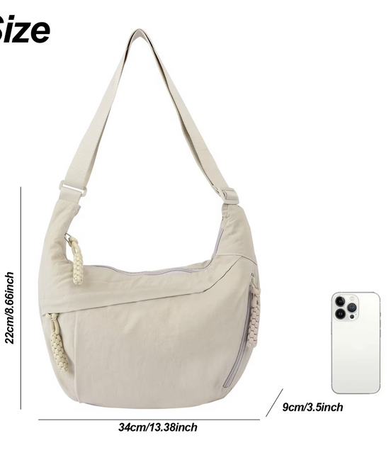 Beige shoulder bag with dimensions and a smartphone for scale on a white background