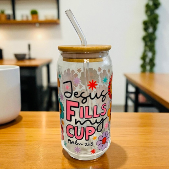 Tumbler with 'Jesus Fills My Cup' text on a wooden table