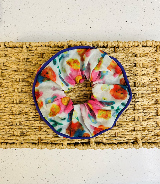 Colorful scrunchie on a woven mat with a white background