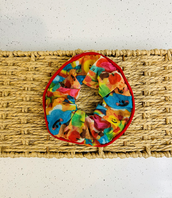 Colorful scrunchie on a woven mat with a white background